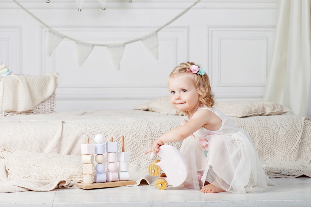 Child girl playing with a wooden toy. Little cute girl with  natural toys.